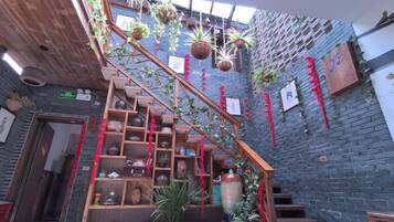 A staircase with wooden railings, potted plants, and hanging baskets.