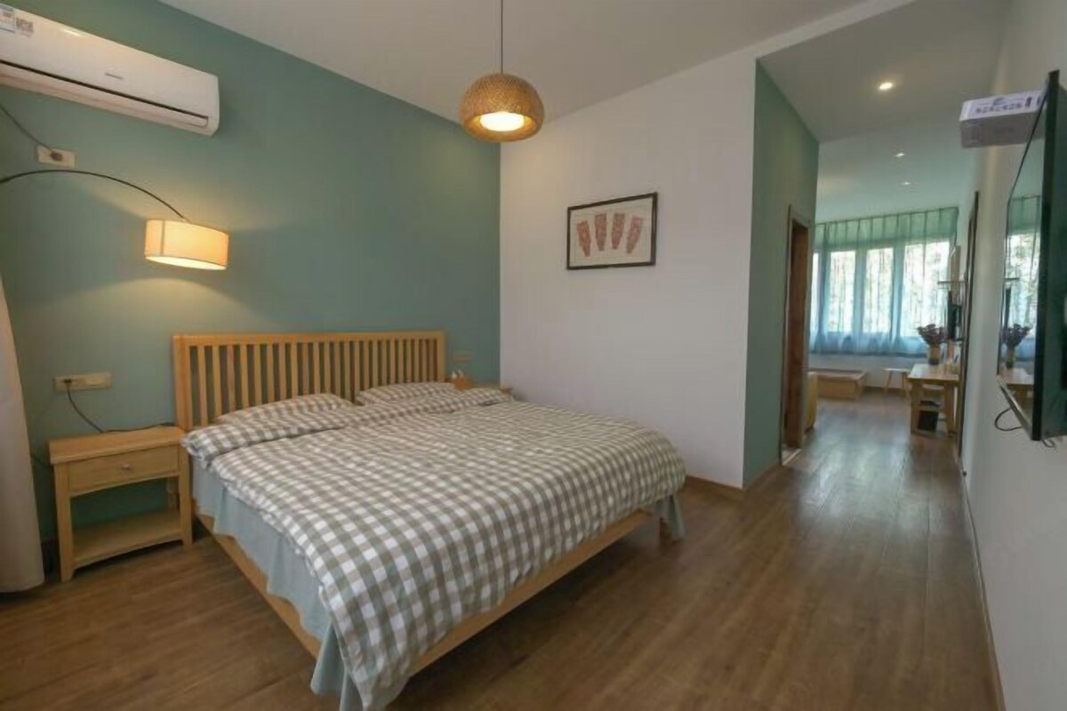 Un dormitorio con cama, mesita de noche, lámpara y un equipo de aire acondicionado.
