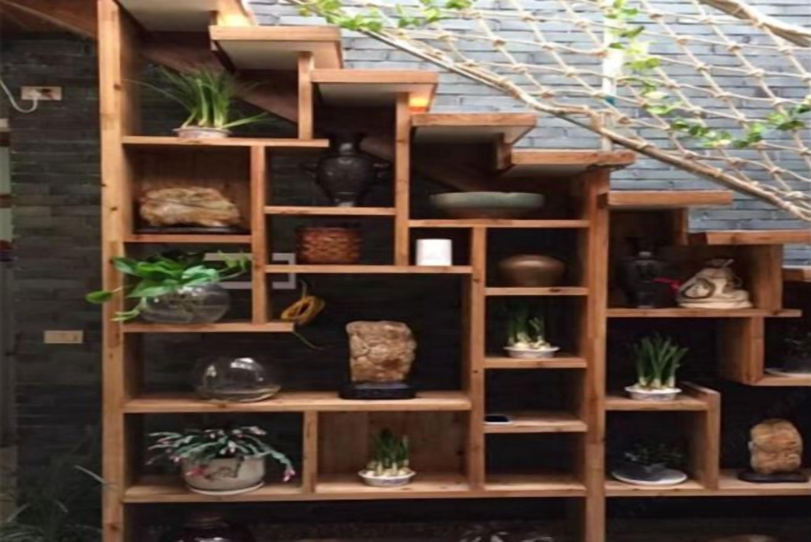 A multi-tiered wooden shelving unit with various decorative items and plants.
