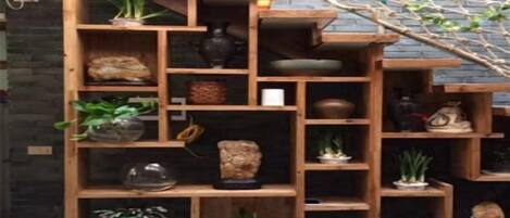 A multi-tiered wooden shelving unit with various decorative items and plants.
