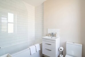 Bathtub, hair dryer, towels, shampoo