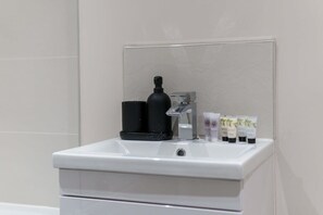 Bathtub, hair dryer, towels, shampoo