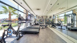 Academia moderna com esteiras, elípticos e aparelhos de musculação.