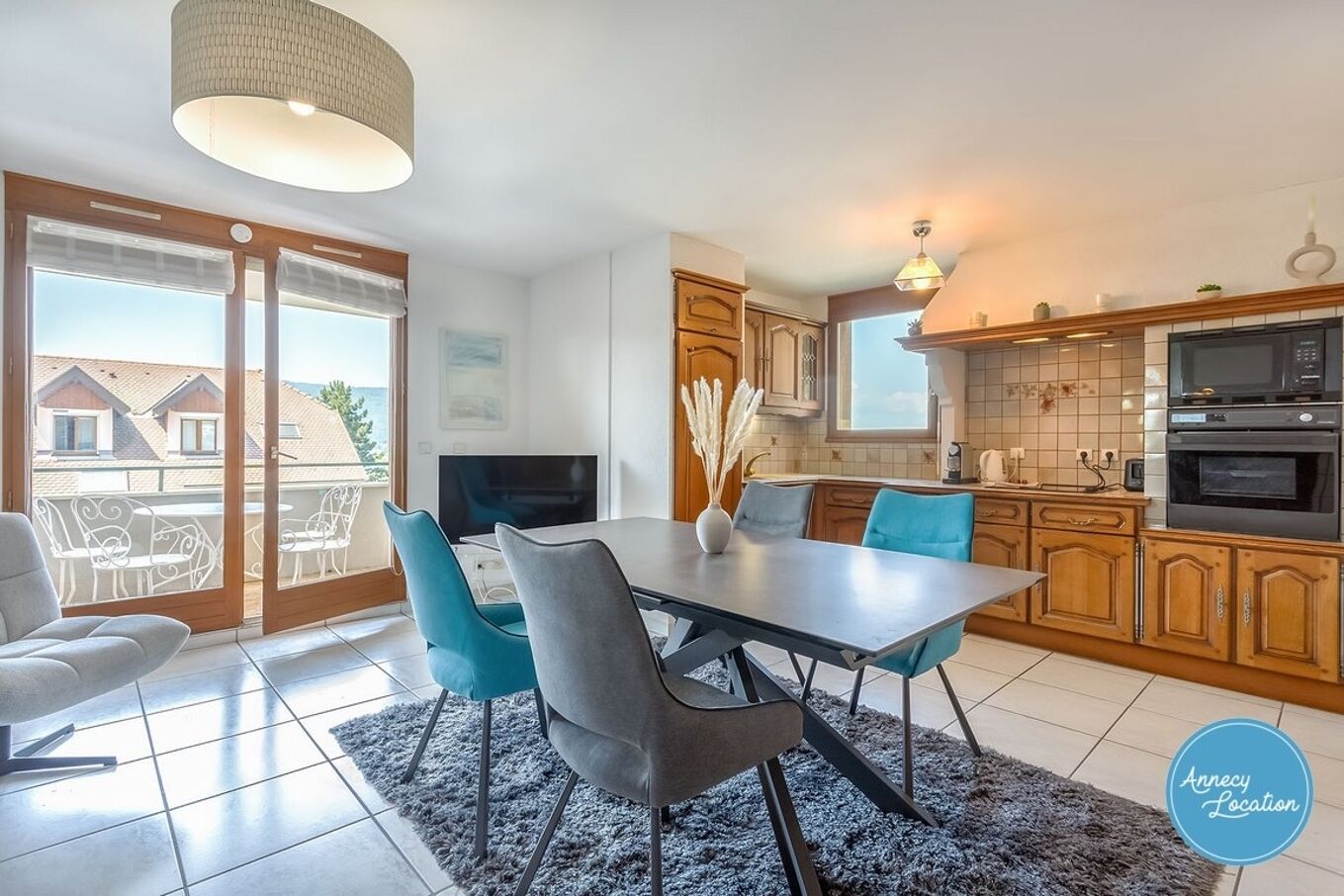 Una cocina moderna con comedor, ventanas amplias y vistas al mar.