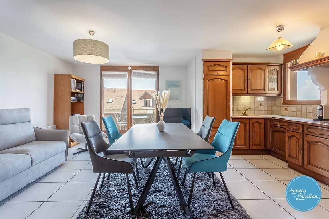 Een moderne keuken met houten kastjes, een eettafel met stoelen en uitzicht op het buitengebied.