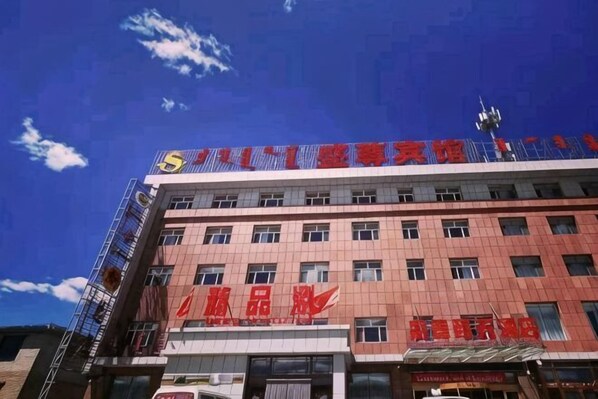 A multi-story building with signage indicating it is a hotel. - Shengzun Business Hotel (West Ujimqin Banner)