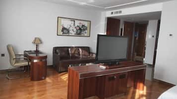 A living room with a television, a sofa, a chair, and a coffee table.