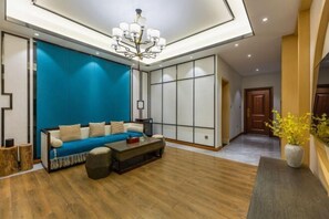 Ein modernes Wohnzimmer mit einem blauen Sofa, einem Couchtisch und einer Chandelier.