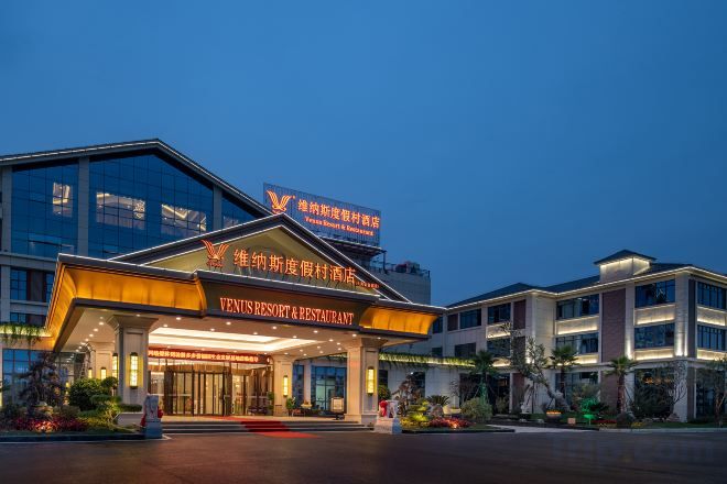 A modern hotel with a prominent entrance, signage for a restaurant, and a well-lit facade.