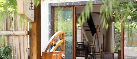 A traditional Japanese-style room with tatami mats, a sliding door, and a view of the garden.