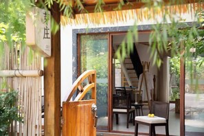 Ein traditioneller japanischer Raum mit Tatami-Matten, einer Schiebetür und Blick auf den Garten.