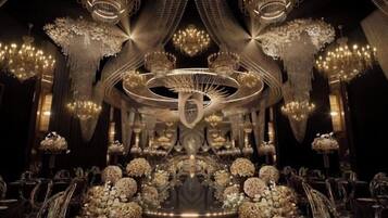 An opulent interior with chandeliers, ornate decorations, and a central circular structure.