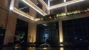 A modern building with a central courtyard featuring a fountain and decorative statues. - Venus Resort (Yidu)