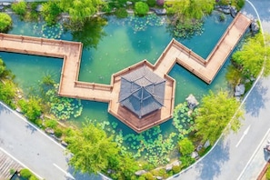 An aerial view of a park with a hexagonal pavilion and a winding water feature. - Venus Resort (Yidu)