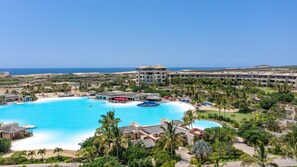 Relax by the pool surrounded by lush greenery and palm trees, with scenic views from the balconies of our resort.