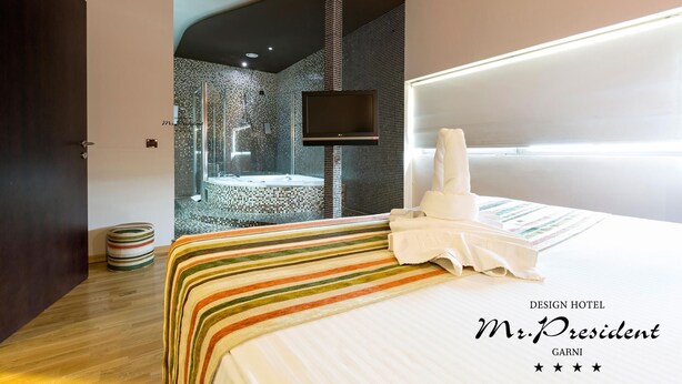 A modern hotel room with a large bed, a TV, a shower area, and a unique wall design. - Design Hotel Mr President (Belgrade)