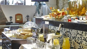A breakfast buffet setup with various food items, a television displaying 'Mr. Prestland', and a decorative fish tank. - Design Hotel Mr President (Belgrade)