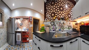 A compact kitchen with a refrigerator, a coffee machine, and a sink. - Maison Fifi (Drâa-Tafilalet)