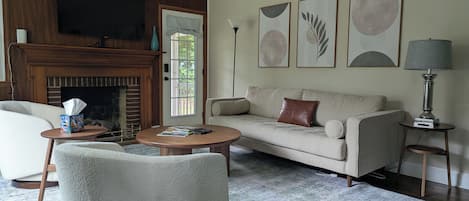 A living room with a fireplace, a sofa, a coffee table, and a television.