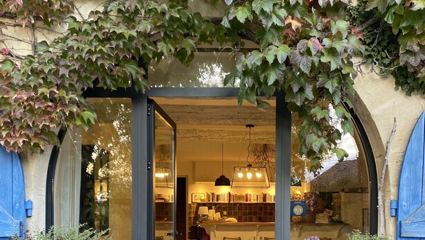 A rustic entrance with a wooden door, potted plants, and pumpkins on the ground. - Bergerie de Beaudine (Forcalquier)