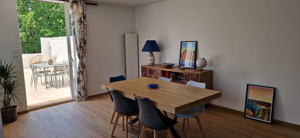 A dining area with a wooden table and chairs, a lamp, a globe, and a framed picture on the wall.