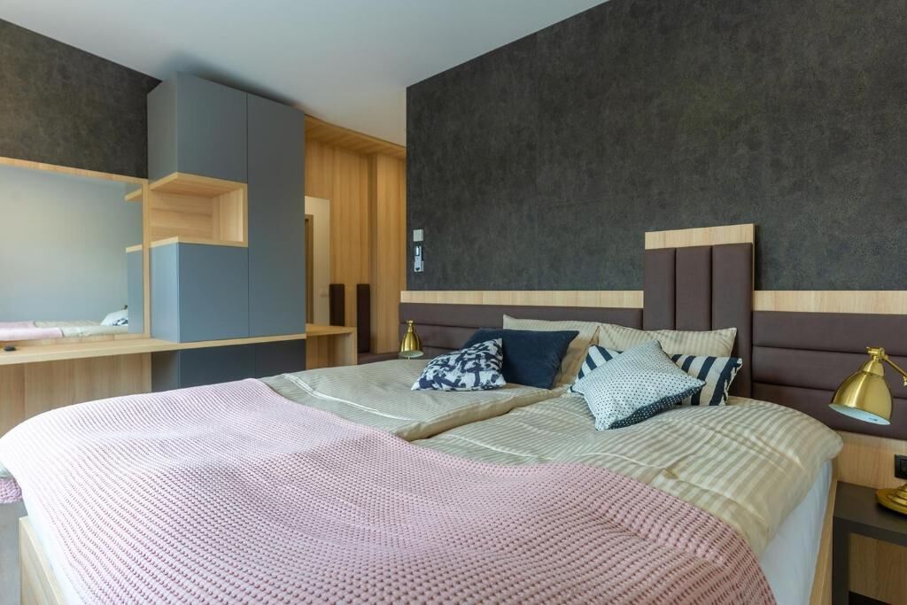 A hotel room with two beds, a desk, and a wardrobe.