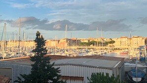 Eine Marina mit zahlreichen angestaubten Booten, umgeben von Gebäuden im mediterranen Stil.