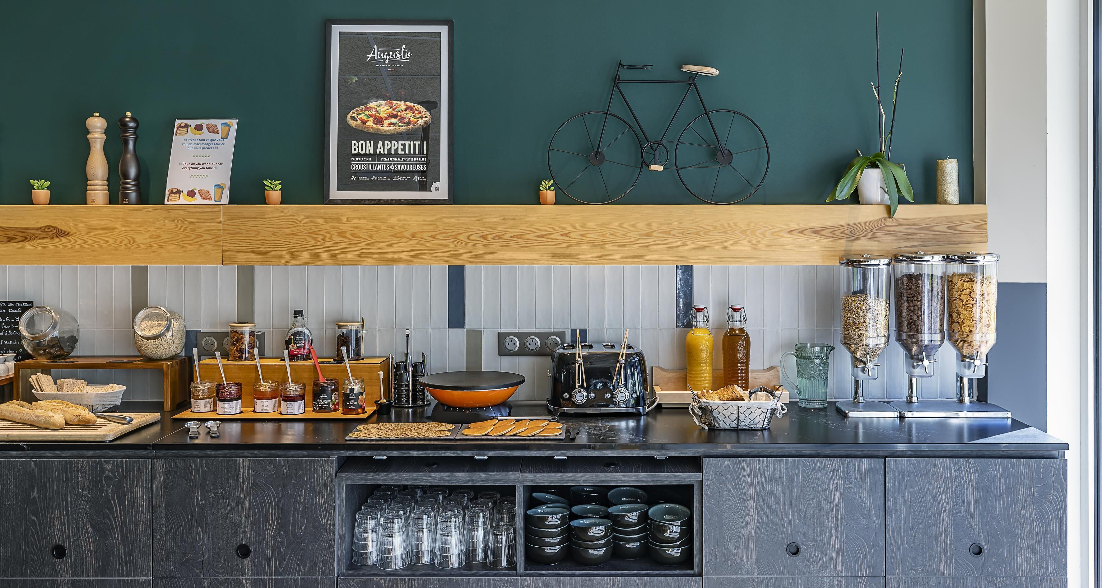 A kitchen counter with various food items, jars, and a bicycle decoration.