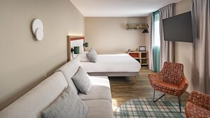 A hotel room with a sofa, a bed, a television, and a chair. - Best Western Coeur de Maurienne Hotel Restaurant & Spa (Saint-Jean-de-Maurienne)