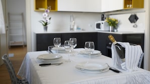 A dining table set with plates, glasses, and cutlery, a bottle of champagne, and a white tablecloth. - Apartment in historic villa 10 minutes from the historic center (Firenze)