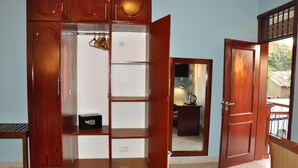Une pièce avec une armoire en bois, un miroir et une porte donnant sur un espace extérieur.