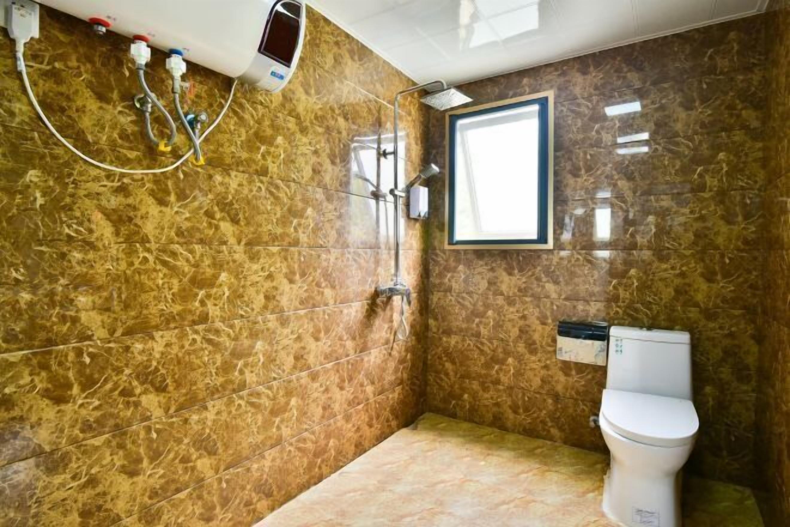 Ein Badezimmer mit Dusche, Toilette und Fenster.