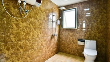Ein Badezimmer mit Dusche, Toilette und Fenster.