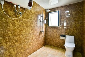 Un baño con ducha, inodoro y ventana.