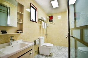 A bathroom with a sink, toilet, and glass shower enclosure. - Caoxi Hepan Resort (Jing County)