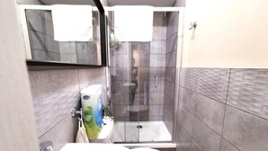 A modern bathroom with a glass-enclosed shower, a sink, and a toilet. - Great Central Location 1BED APT Off OConnell ST (Dublin 1)