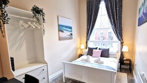 A bedroom with a bed, bedside tables, a wardrobe, a window with curtains, and a view of the outside. - Great Central Location 1BED APT Off OConnell ST (Dublin 1)