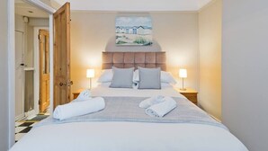 A hotel room with a bed, two bedside tables, a headboard, and a painting on the wall. - Great House Trendy Ranelagh 3bed 2bath TV and WIFI (Dublin 6)