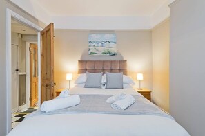 A hotel room with a bed, two bedside tables, a headboard, and a painting on the wall. - Great House Trendy Ranelagh 3bed 2bath TV and WIFI (Dublin 6)