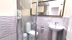 A bathroom with a glass shower enclosure, a toilet, a sink, and a mirror. - Cosy Apartment near OConnell St Reliable Fast WIFI (Dublin 1)