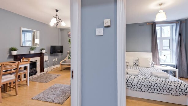 Ein modernes Schlafzimmer mit Bett, Nachttisch und einem großen Fenster.