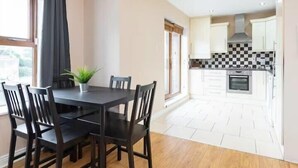 A modern kitchen with white cabinets, a black and white checkered backsplash, and a built-in oven. - Great City CENTRE LOCATION SPACIOUS 2 BED APT (Dublin 1)