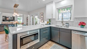 A modern kitchen with a built-in oven, a large island, and a window with a view.