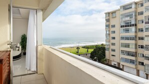 A balcony with a view of the ocean and a building across the street. - New Cumberland 405 (Cape Town)