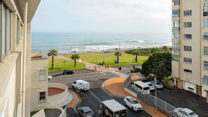 A coastal view from a balcony overlooking a street with cars and a pedestrian crossing. - New Cumberland 405 (Cape Town)
