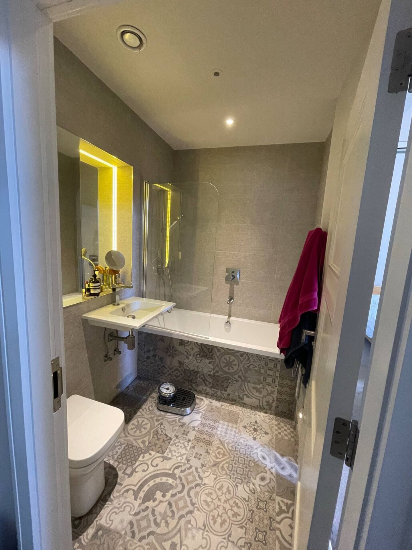 A modern bathroom with a toilet, sink, and shower.