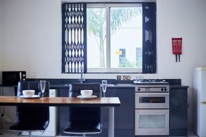 A compact kitchen with a dining area, a gas stove, an oven, and a microwave. - Beautiful one bed Apartment in Tema, Community 6 (Tema)