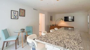 Eine moderne Küche mit Granit Arbeitsplatte, Deckenventilator und Essbereich mit Stühlen und Tisch.