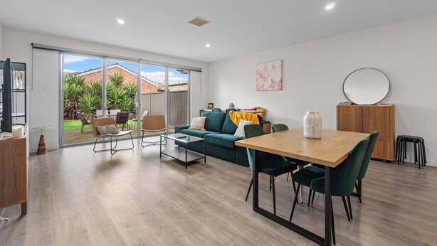 A modern living room with a dining area, large sliding glass doors to a backyard, and a view of a brick house. - Mellow&Modernized Townhouse-3Beds-Quiet-Anzac Hwy (Plympton)