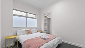 A hotel room with a bed, a window, a closet, and a small table. - Mellow&Modernized Townhouse-3Beds-Quiet-Anzac Hwy (Plympton)